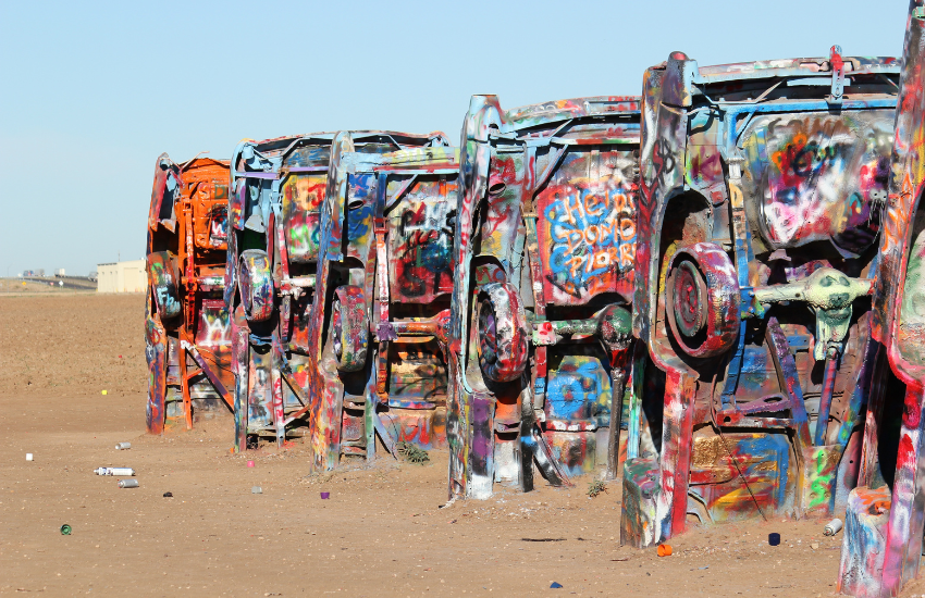 grafiti cars half buried in the ground