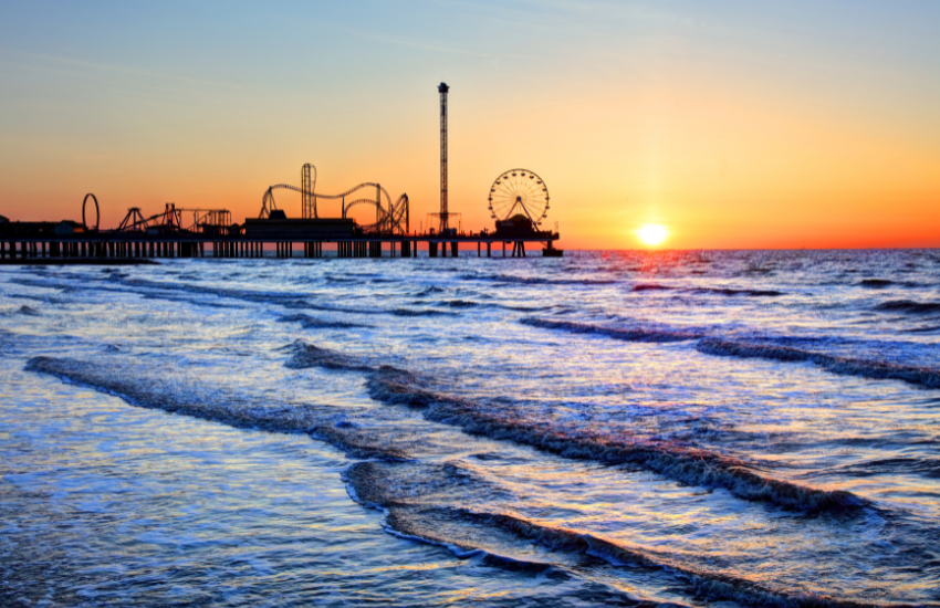 a pier and a ferris wheel at sunset