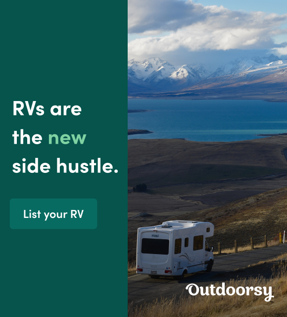 RV on a remote road going towards mountains.
