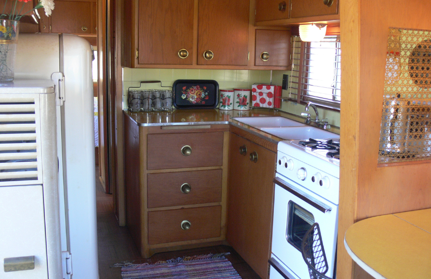 Brown wooden cabinets in a vintage camper kitchen.
