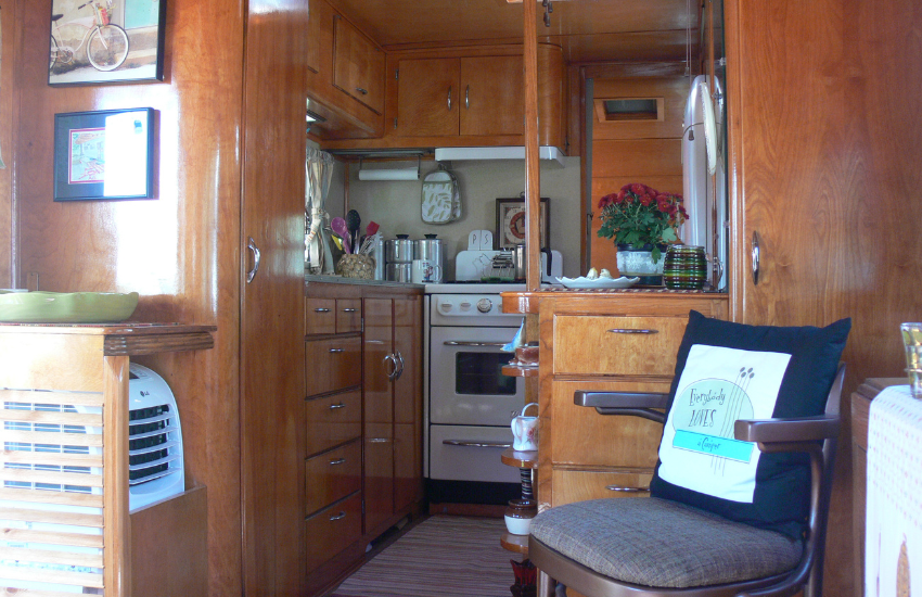 Lots of wooden cabinetry inside an old camper.