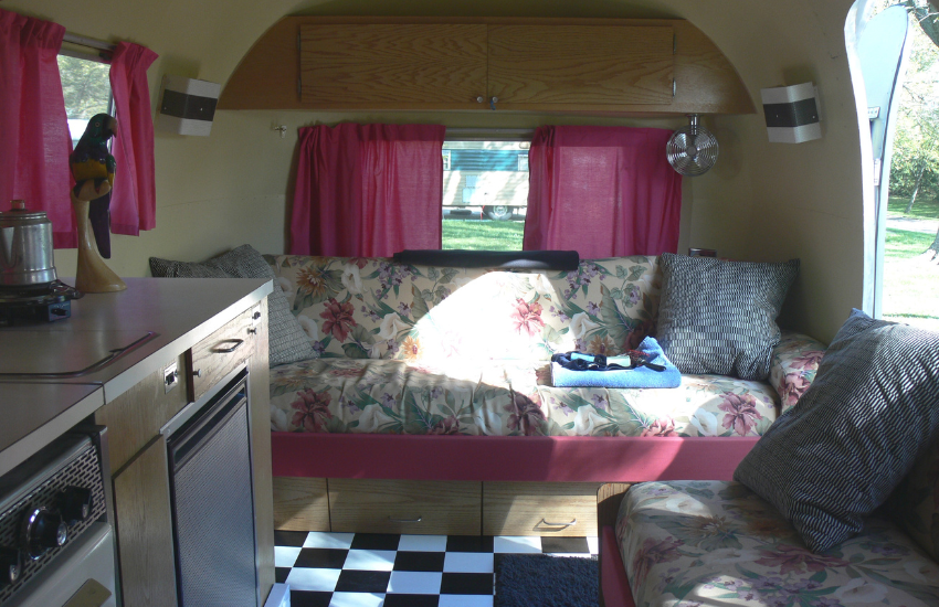 Shocking pink curtains and floral patterned benches in a vintage travel trailer.