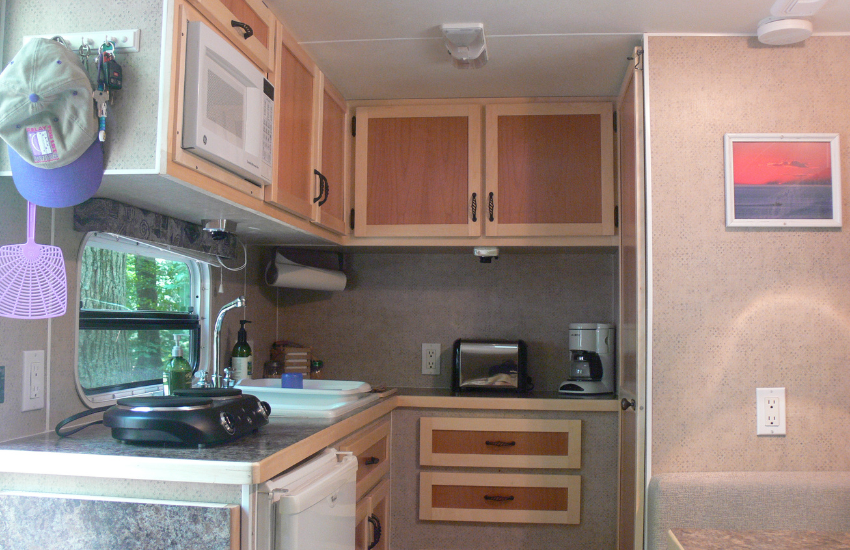 An old RV kitchen with wooden cabinet doors.