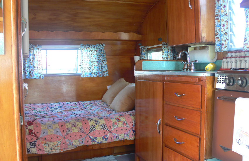 Colorful bed and curtains in an old camper.