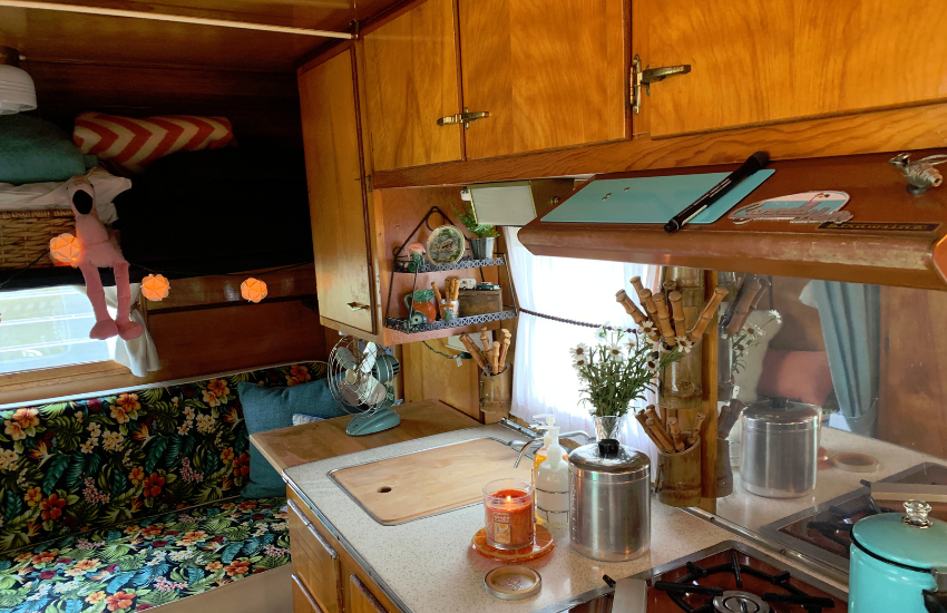 Kitchen area and floral bench seat in a vintage camper trailer.