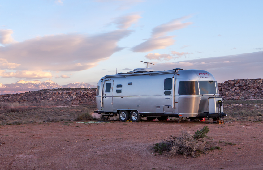 A silver RV trailer parked in the desert.