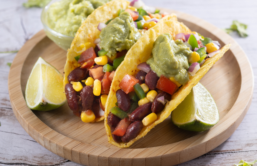 Black bean tacos on a wooden plate.