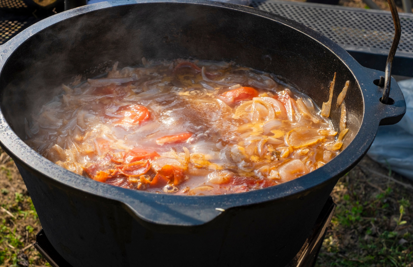 A big pot of stew on a campfire.