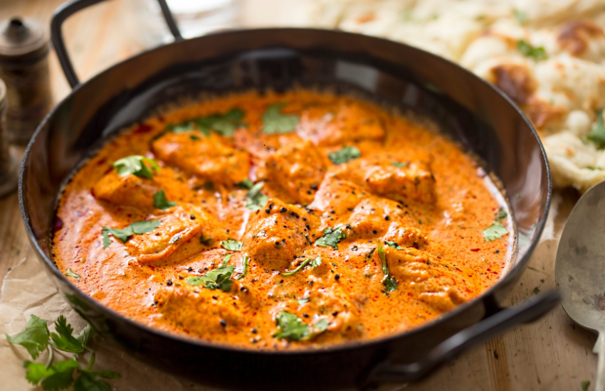 Chicken curry in a black bowl.
